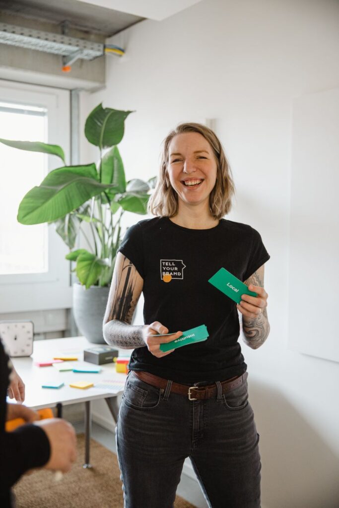 Luisa Häußer in Workshop-Situation mit Nachhaltigkeitskarten in der Hand